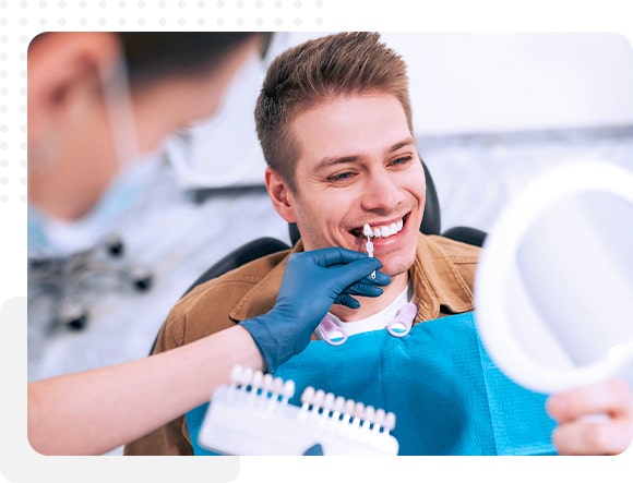 Dentist comparing veneer shades to natural teeth